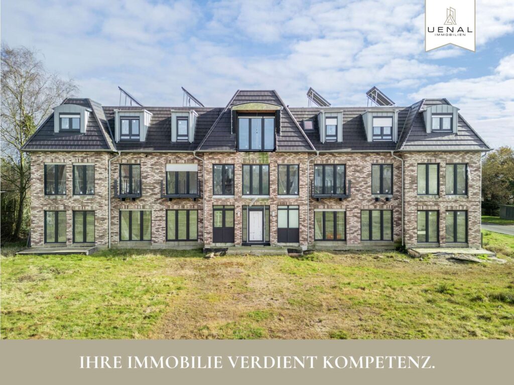 Symmetrisches Mehrfamilienhaus mit heller Klinkerfassade, dunklem Dach und Solarpanelen – Werbebild mit dem Slogan ‚Ihre Immobilie verdient Kompetenz‘ von Ünal Immobilien.